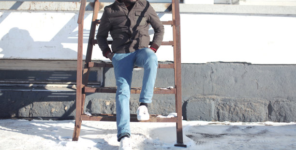 穿着夹克和牛仔裤的时尚男士在城市中摆姿势图片下载