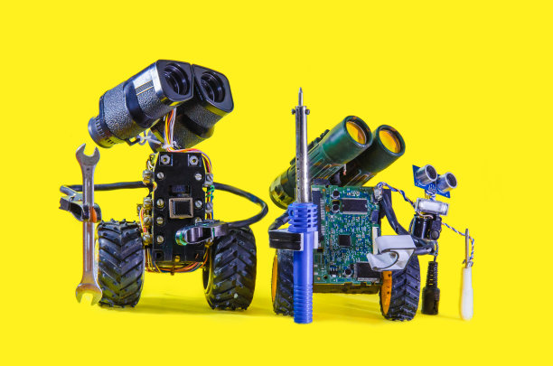 三个机器人正用扳手、螺丝刀和烙铁在侧面看向远处图片下载