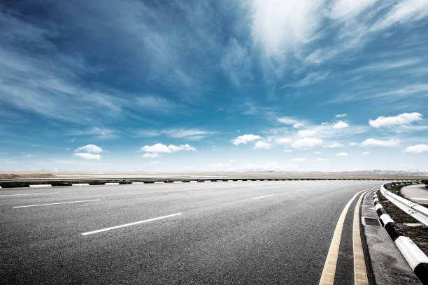 空旷的柏油路和蓝天下的雪山图片下载