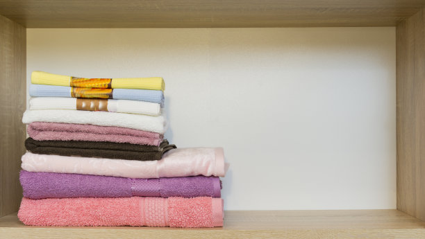 新颜色的毛巾堆在衣柜的架子上图片下载