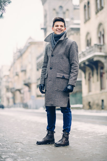 穿着灰色保暖外套和皮手套的年轻时尚男子图片下载