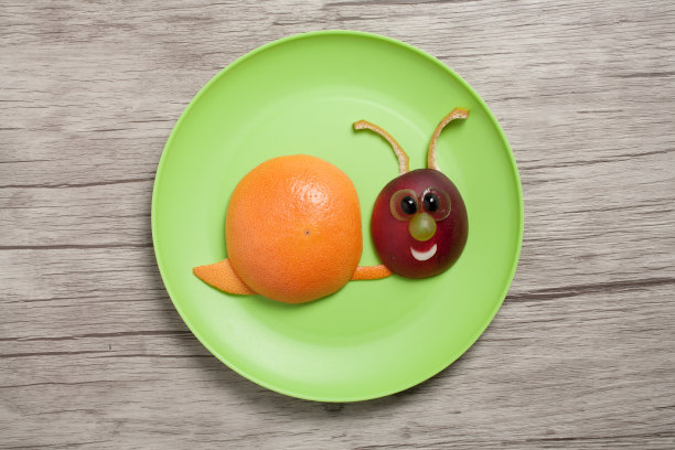 蜗牛做成的水果在盘子和桌子上图片下载