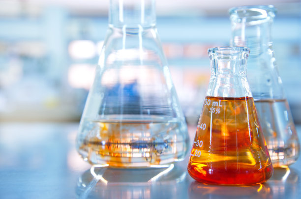 有科学实验室背景的橙色溶液的玻璃烧瓶图片下载