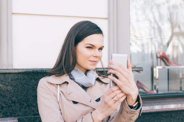 身着米色外套的年轻女子自拍图片下载