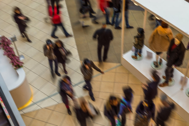 模糊的人在运动模糊，冲在购物中心的大厅。从上面的观点图片下载