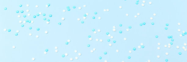 白色和蓝色的雪花洒在蓝色。节日的背景。庆祝活动的概念图片下载