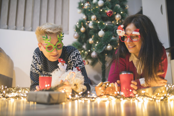 两个女人和狗分享圣诞/新年礼物图片下载