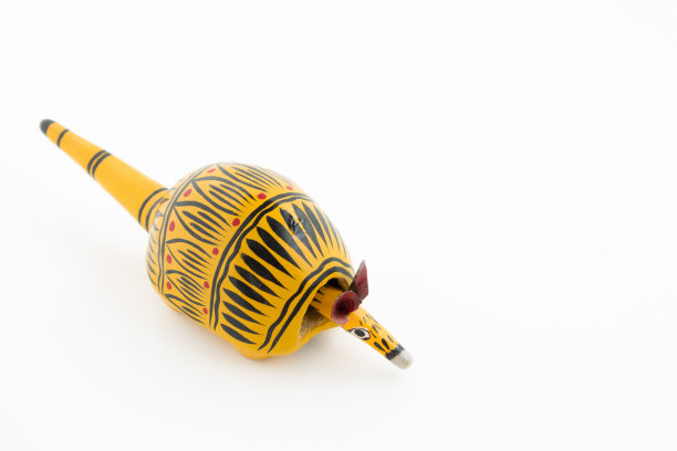 黄色木制犰狳玩具与黑色标志和摆动头在白色的背景图片下载