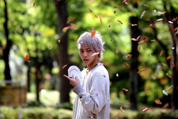 年轻人在落叶间玩魔术图片下载