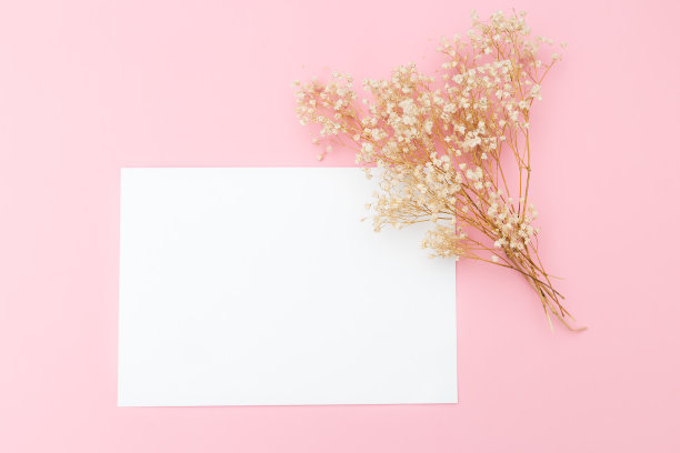 一束白花和一张粉红色背景上的题词卡片图片下载