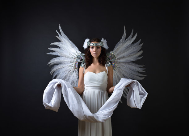 穿着白衣，长着天使翅膀的女人。图片下载