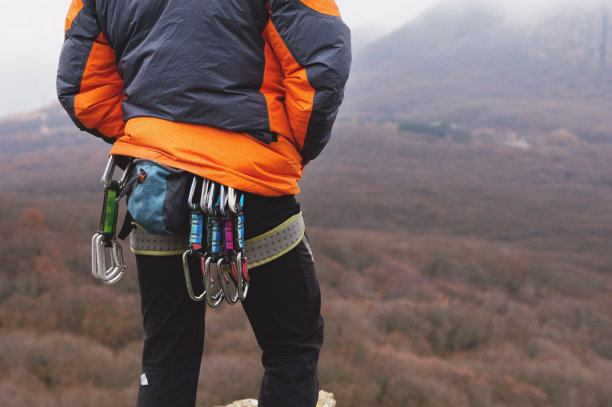 特写的大腿攀登者与设备上的皮带，站在岩石上图片下载
