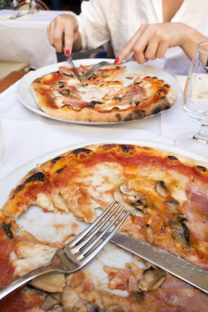 意大利佛罗伦萨，用刀叉吃了一半披萨图片下载