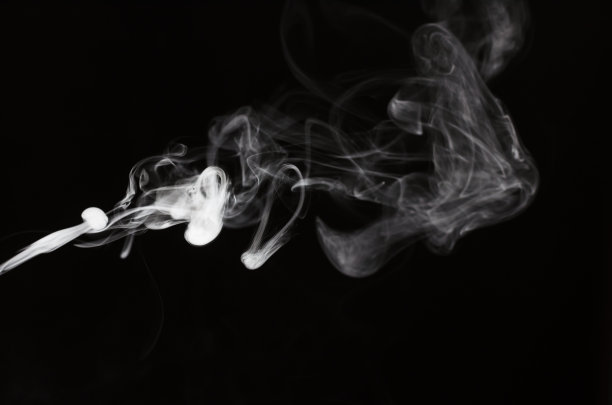 烟雾在黑色背景与美丽的运动流动从一边在中间。图片下载