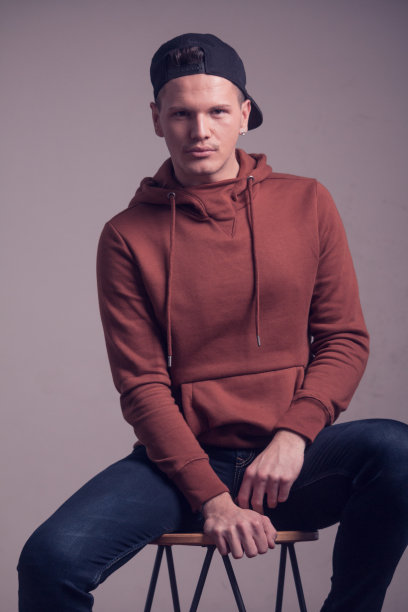 一个年轻的男人，20出头，男孩子的样子，在工作室摆姿势，休闲的衣服，运动衫帽，上半身的照片图片下载