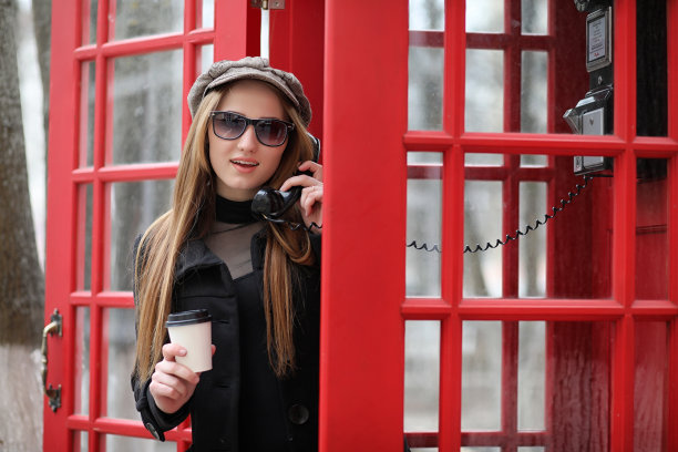 电话亭里的漂亮姑娘。那个女孩正在讲电话图片下载