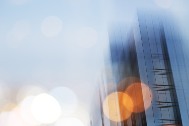 摘要商业现代城市城市未来建筑背景。房地产概念，动态模糊，高层摩天楼立面的玻璃反射，色调蓝色的画面与散景图片下载