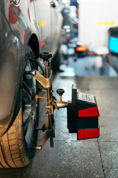 特写轮胎夹紧与定位器正在进行汽车车轮对准图片下载