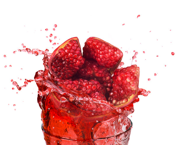 白色背景上装在玻璃杯中的石榴汁和切开的石榴图片下载