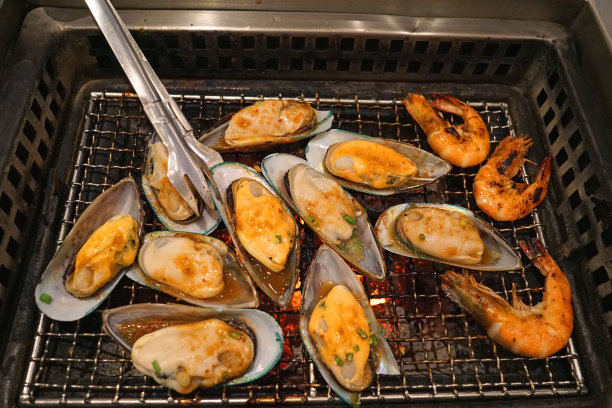 在红热的火炉上烤香辣大贻贝图片下载