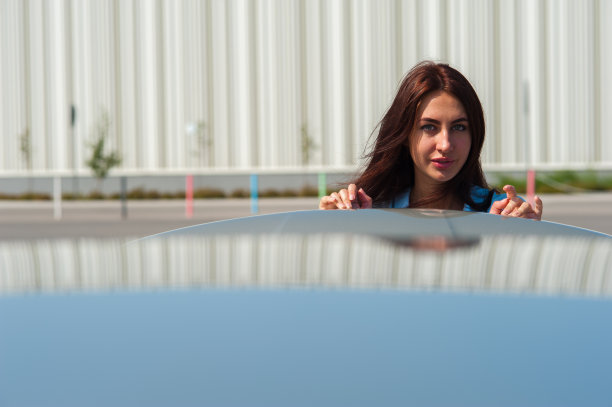 站在银色汽车旁边的美丽年轻女人图片下载