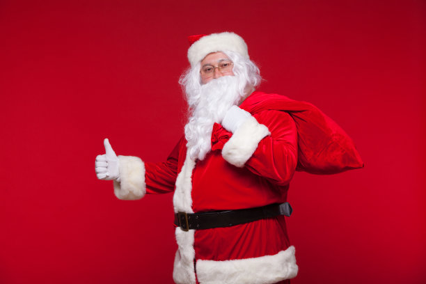 圣诞节。红色背景上是肩上背着大袋子的圣诞老人图片下载