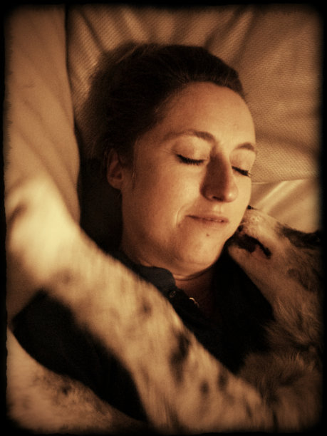 一个女人正在和她的澳洲牧羊犬狗放松图片下载