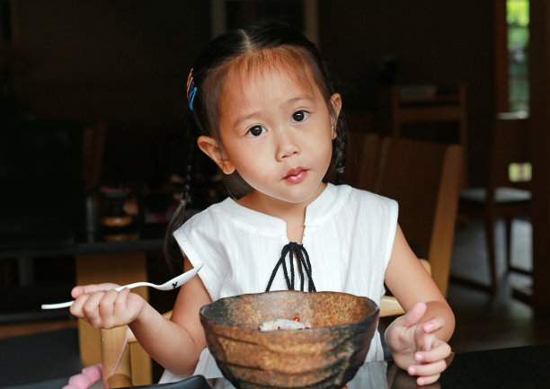 亚洲小女孩吃米饭美味的日本食物在餐桌上的午餐在餐厅。素材图片