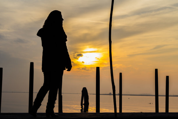 阳光下戴着墨镜和大围巾的威尼斯优雅女士图片下载