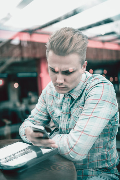 年轻英俊的男性在咖啡馆阅读他的待办事项清单图片下载