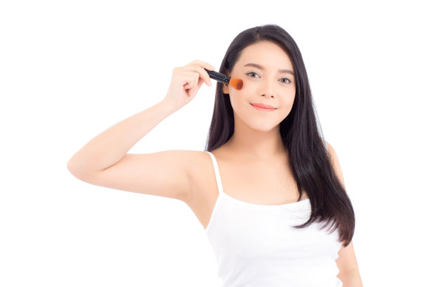 美丽的亚洲女人用腮红刷在白色的背景上化妆，美丽的女孩拿着腮红，护肤和化妆的概念。图片下载