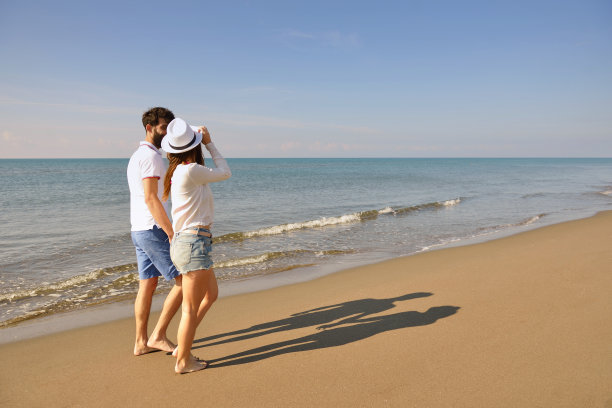 年轻幸福的夫妇在海边。男性有胡子。图片下载