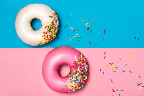 甜甜圈与糖霜的色块背景。可爱的甜甜圈。图片下载