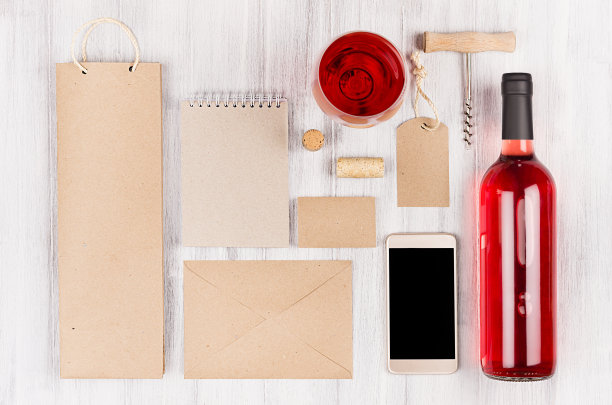 企业身份模板葡萄酒行业，包装，文具，电话，葡萄酒杯设置与瓶玫瑰葡萄酒在柔软的白色木材背景。图片下载