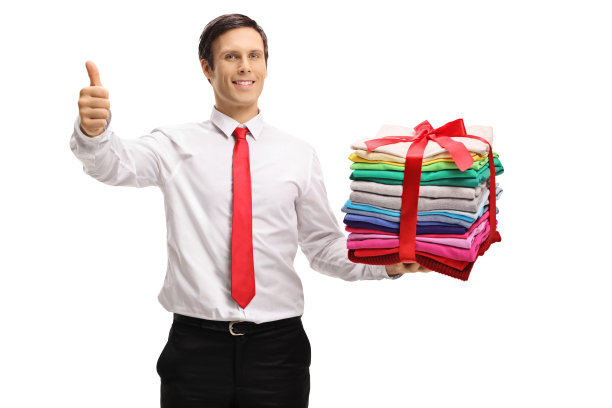 一个穿着正式的男人，拿着一堆熨烫过的打包好的衣服，竖起大拇指图片下载