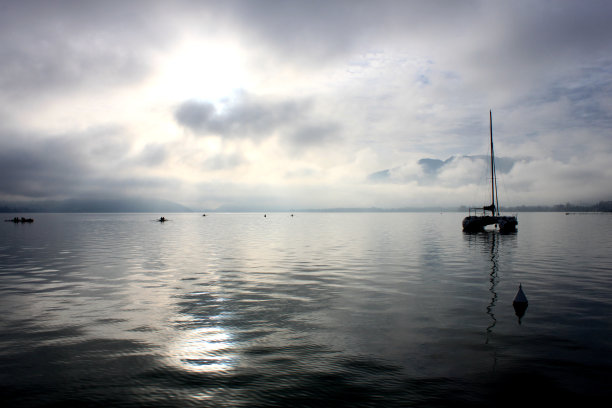 在冬天的早晨，蓝色的安尼西湖上有几只小鸟和群山图片下载