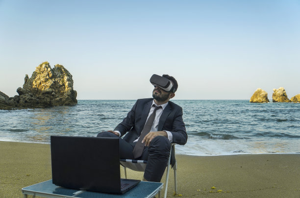 在海滩上使用虚拟现实的商人图片下载