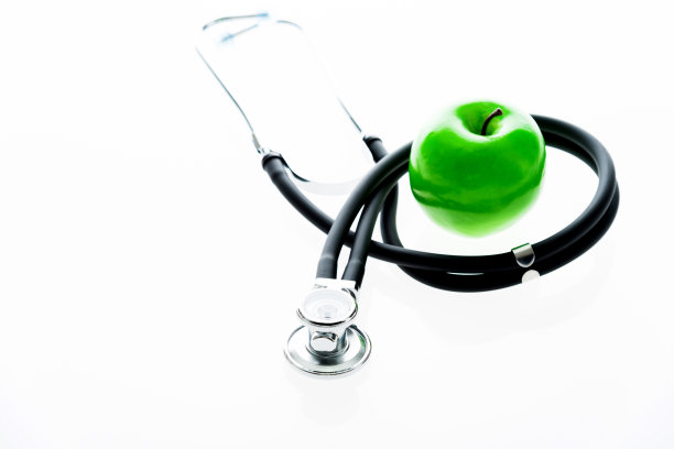听诊器和绿苹果在白色的背景素材图片