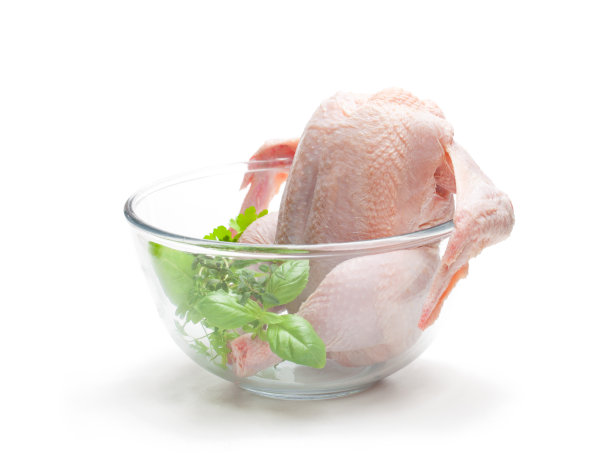 生鸡肉和香草在透明的玻璃碗孤立在白色的背景。准备做饭。图片下载