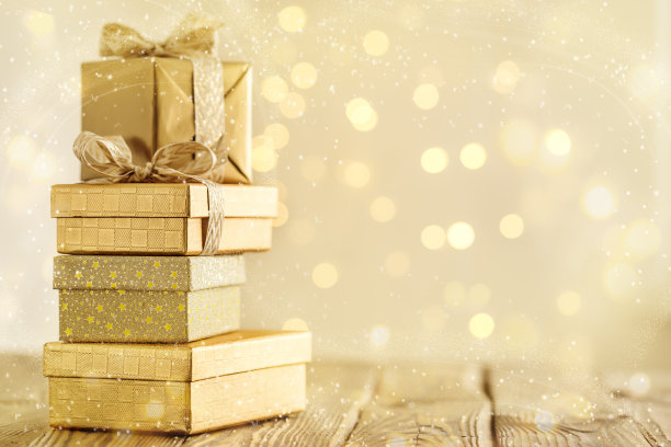 用金色丝带包裹着的盒子在闪闪发光的魔法雪中。图片下载