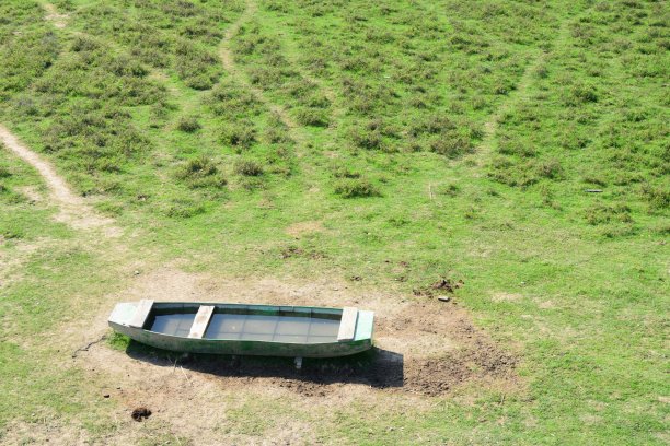 被遗弃的船只残骸在草地上，还有一条网状的人行道图片下载