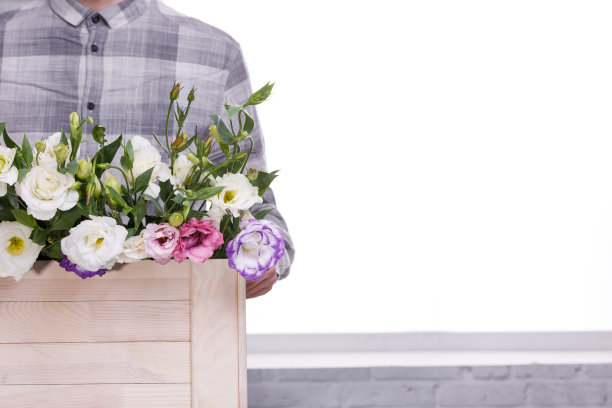 图中的男子并没有完全拿着一个装着玫瑰花的盒子素材图片