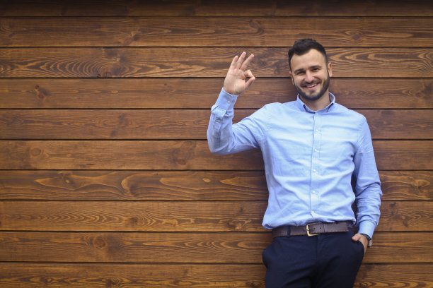 一个英俊男子的肖像在一个木制的墙壁背景衬衫。商人，穿着时髦的老板。设计素材照片图片下载