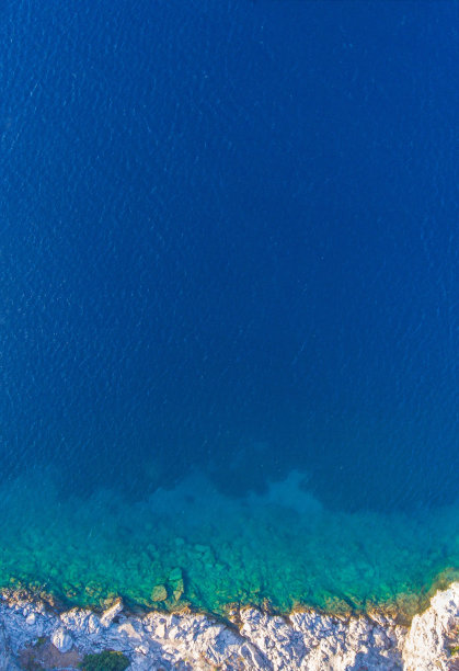 清澈的海水与岸边的岩石相连。鸟瞰图。图片下载