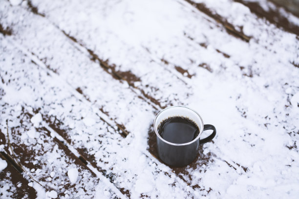 户外，雪白的木桌上放着咖啡杯图片下载