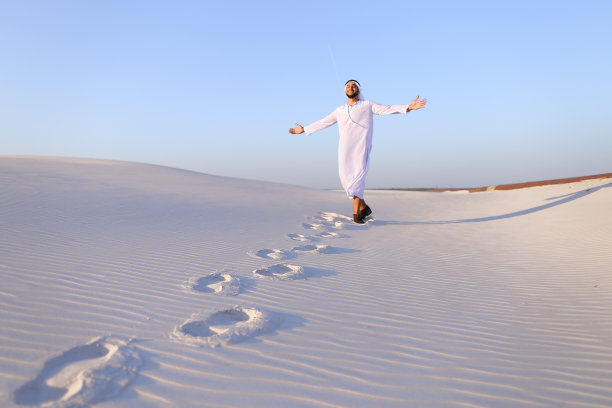 快乐穆斯林男子漫步白色沙漠图片下载