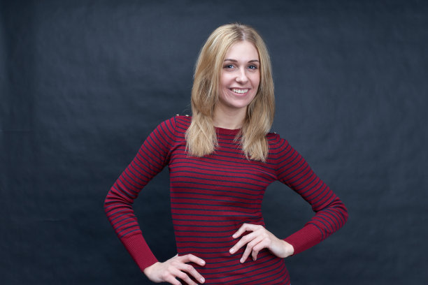 肖像工作室在黑色的背景微笑年轻的长发迷人的女人摆姿势肖像与宽微笑的牙齿。图片下载