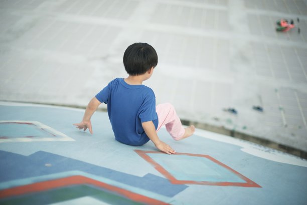 滑下公园滑梯的男孩的背面图片下载