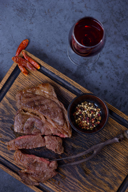 桌上放着烤牛排片和红酒图片下载