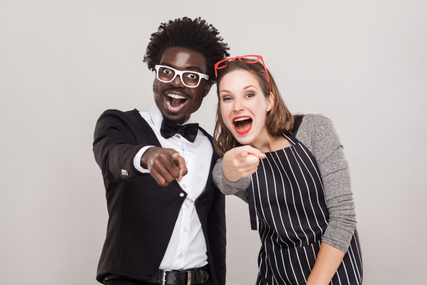 嘲笑,嘲笑的概念。一对五彩缤纷的情侣指着镜头图片下载